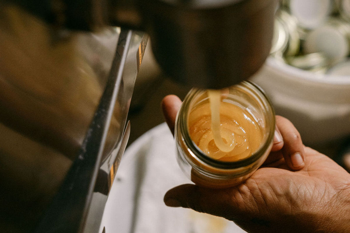 machine filling a jar with raw honey